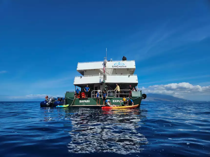 small cruise ship floating in Hawaiian ocean off loading kayaks off the safari explorer 