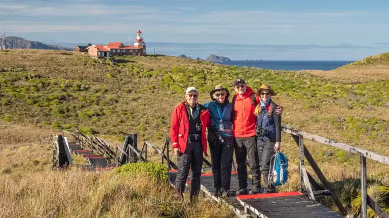 Lindblad guests in front of the Cape Horn lighthouse and small chapel at Cape Horn, Cabo de Hornos National Park, Hornos Island, Chile.