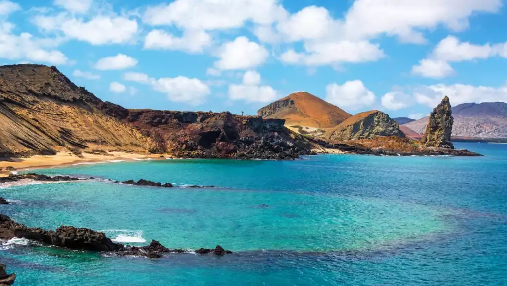 An underwater crater in the foreground with Pinnacle Rock in the background on Bartolome Island in the Galapagos Islands.