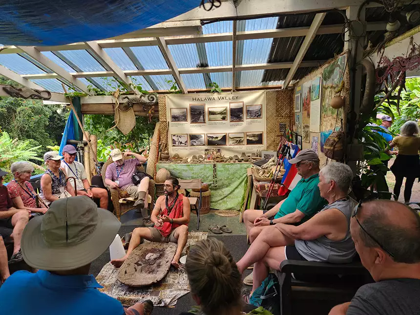 Travelers seen circled around a local guide in the Halawa Valley in Hawaii