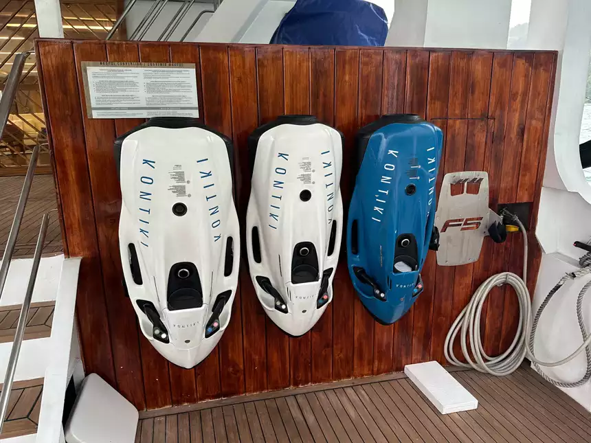 blue and white seabobs that are being charged and ready for swmmers to use aboard small cruise ship 