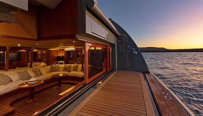 The back deck of the luxury Galapagos yacht Aqua Mare showing the swim deck and open doors to a large couch lounge