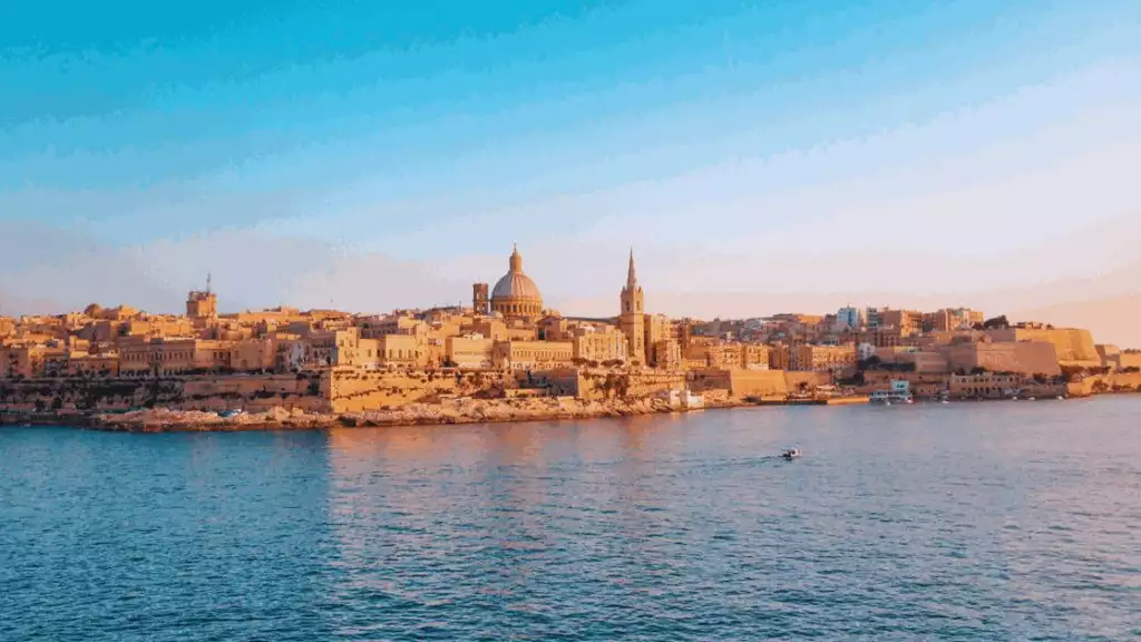 waterway in front of historic city with golden sunlight reflecting on the old tan city