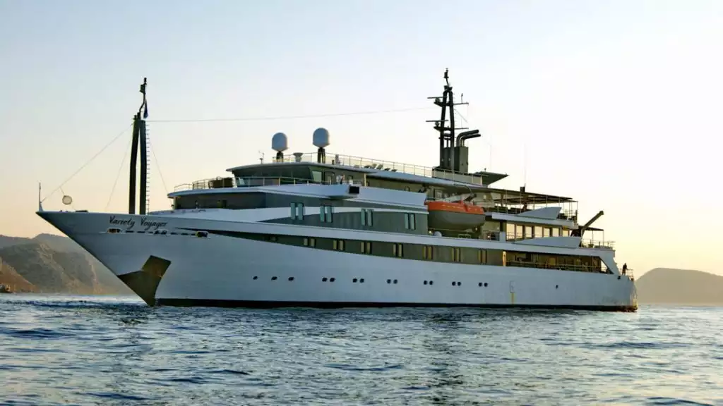 Small cruise ship with large windows on a calm evening with the sun setting