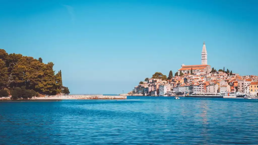 water view of costal town of Rovinji Croatia off in the distance with green trees