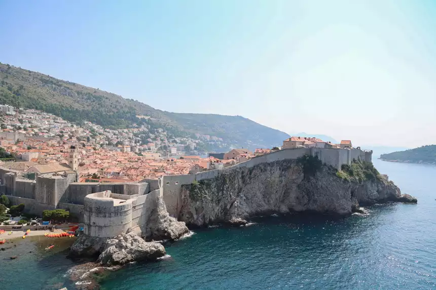 Dubrovnik walls on the cliff as seen from a nearby tower with red roofs inside the walls in the Old Town