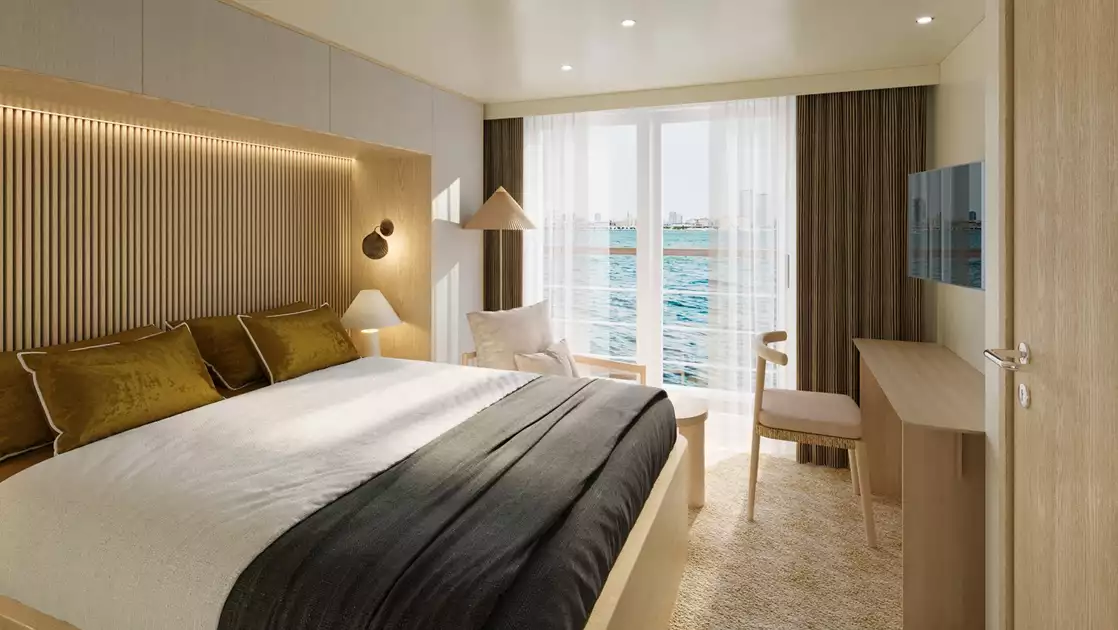 Horizon Suite of Paspaley Pearl ship with double bed in white & black linens, private balcony, TV, desk & beige wood accents.