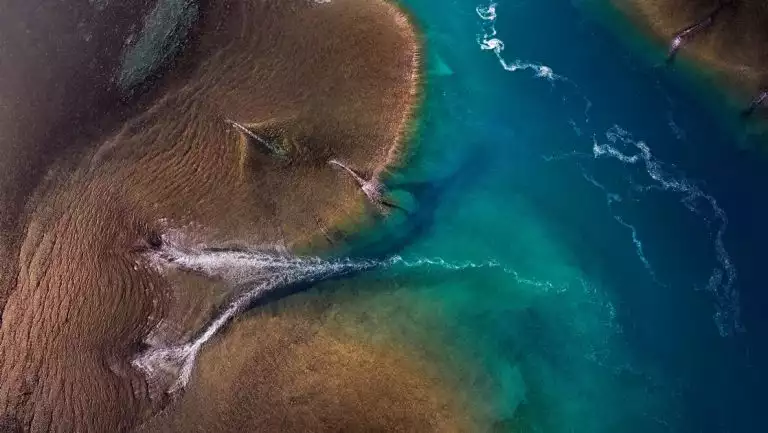 Aerial view of reef with brown, blue & turquoise sea channels, seen on the PASPALEY PEARL Unexplored Kimberley cruise.