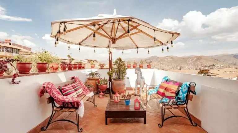 Outdoor patio at the Andenes boutique hotel with colorful seating and a beautiful umbrella on a sunny day