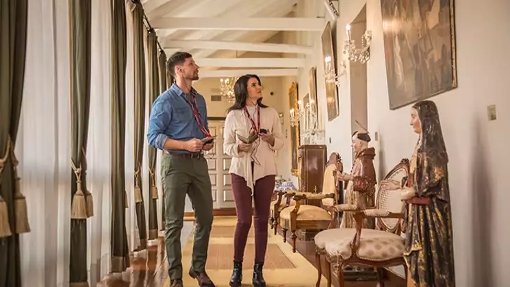 Hotel guests, a man and women explore the antiques of the Aranwa Cusco boutique hotel