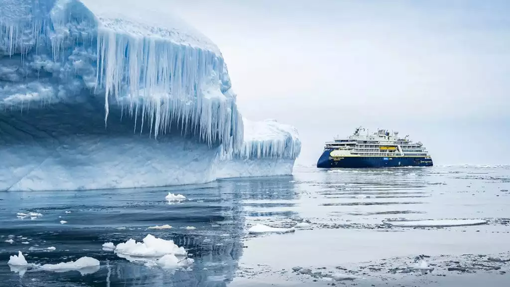 Small expedition cruise ship exploring the icy coast and landscapes of antarctica