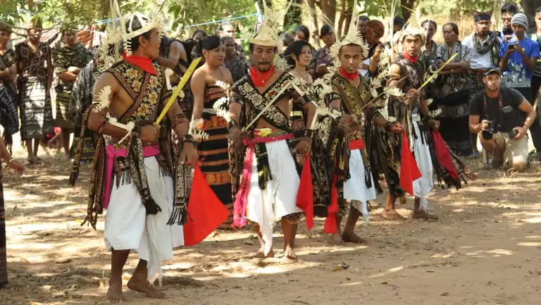 Savunese people show off their culture through dance in colorful garb as visitors look on during an East Indonesia cruise.