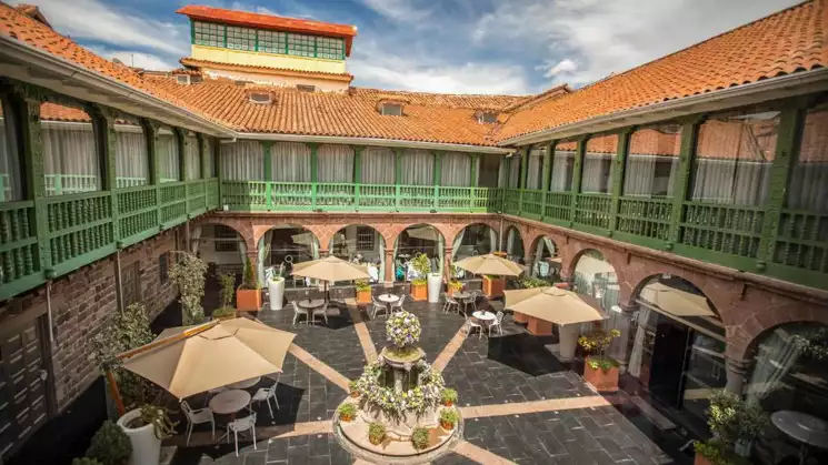 Exterior of Aranwa Cusco Boutique with green and red terracotta roofs ariel view of hotel on a sunny day