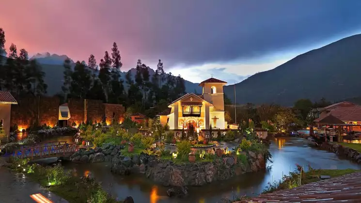 Beautiful entry way to the Aranwa sacred valley hotel & wellness with a pink and purple sunset off in the distance