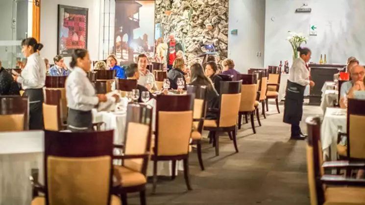 Dining area at the aranwa sacred valley hotel for up to 130 people with brown and tan chairs and white table cloths