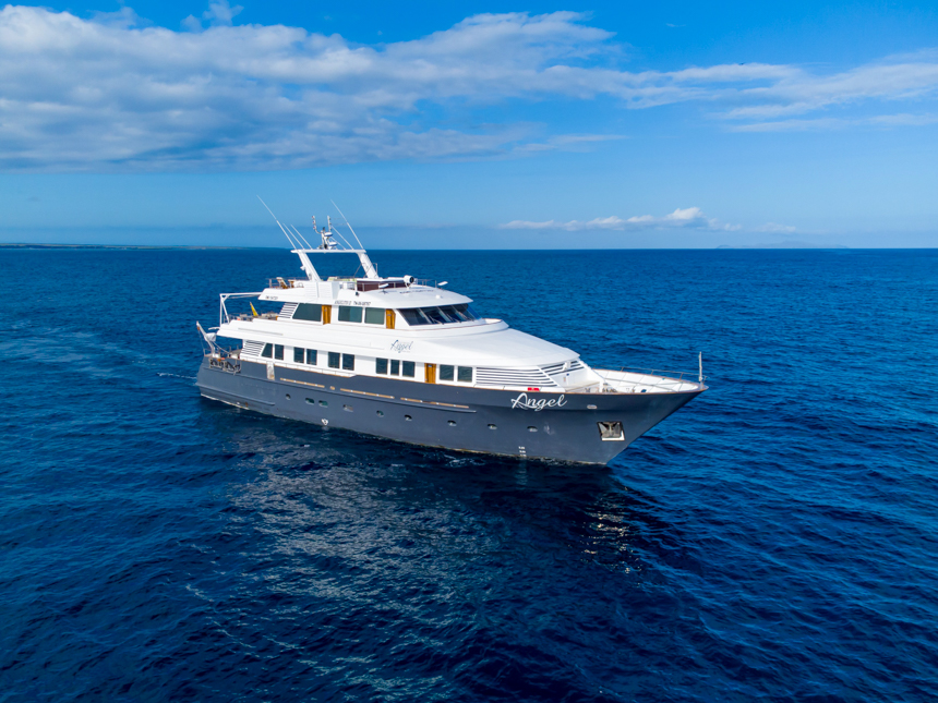 Small cruise ship cruising through the bright blue waters on a bright sunny day