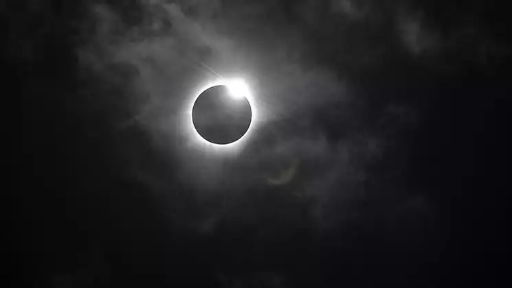 Black sky with black sun with white ring around it due to being fully eclipsed by the moon, seen on a Mediterranean cruise.