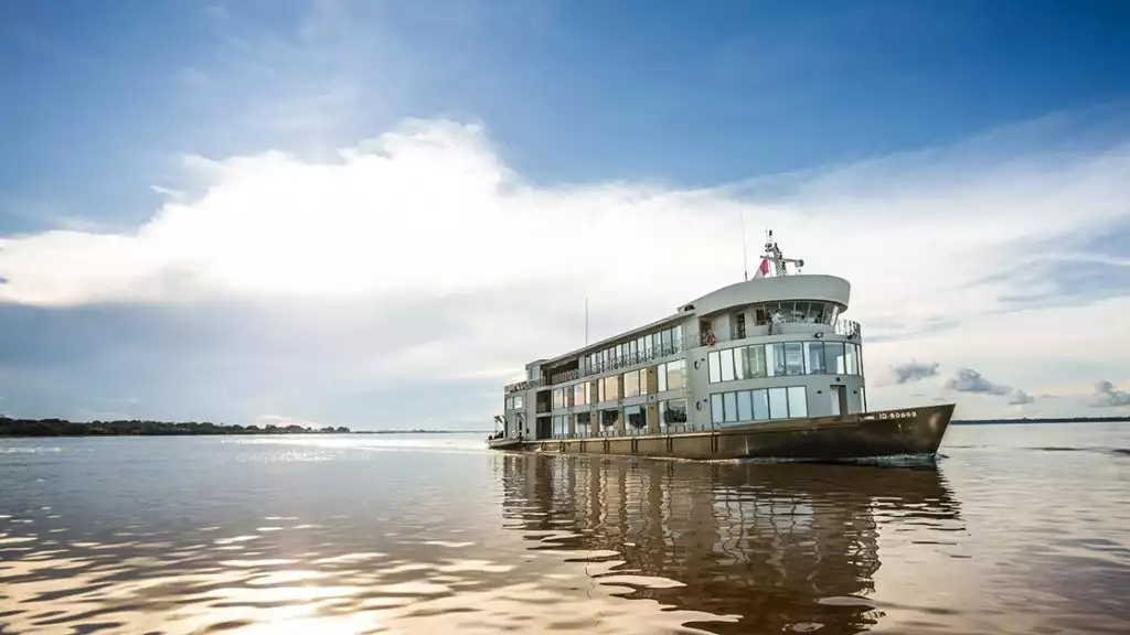 Small cruise ship cruising the Amazon on a calm cloudy day