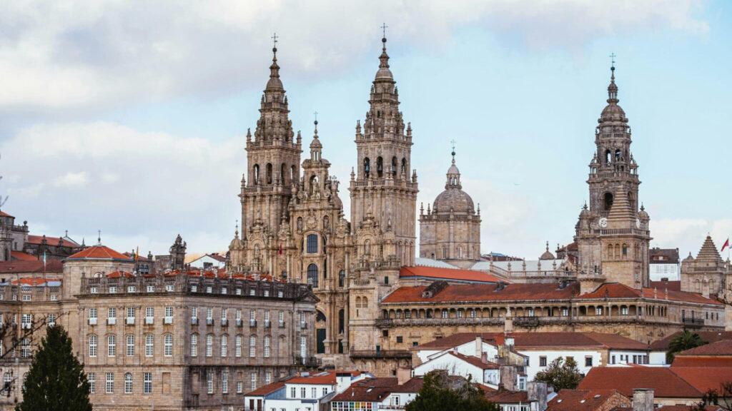 beautiful historic buildings towering over the city with red roofs on a cloudy day in Spain