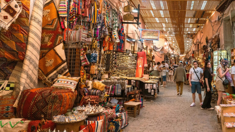 Colorful Moroccan street market with merchandise along both sides and shoppers roaming the market