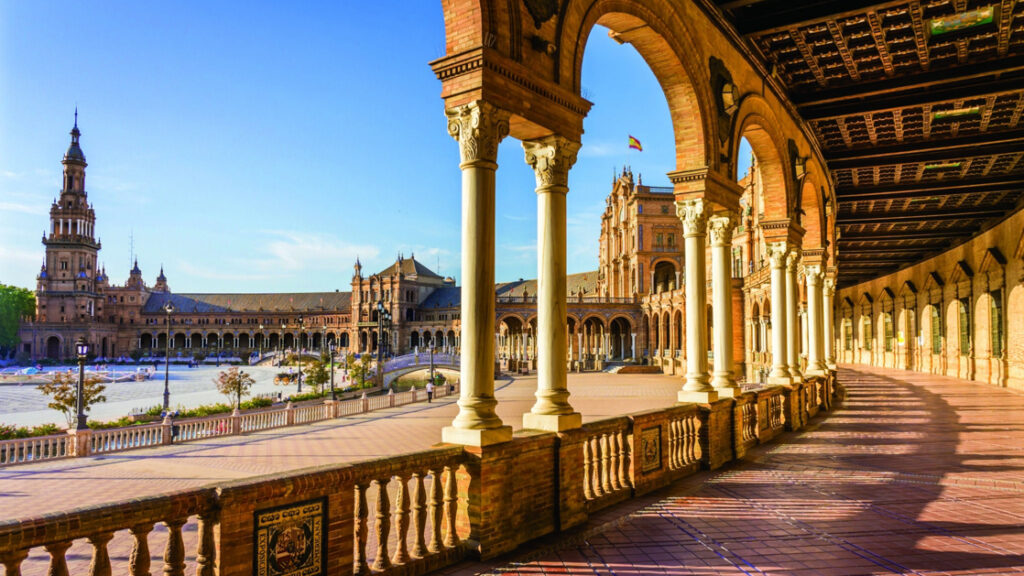 Open air walkway around the Seville plaza in Spain with beautiful arches and call beams on a bright sunny day