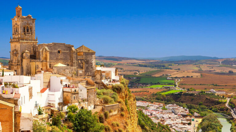 Historic city in Spain, with a church on the top of a large hill looking down on the valley below