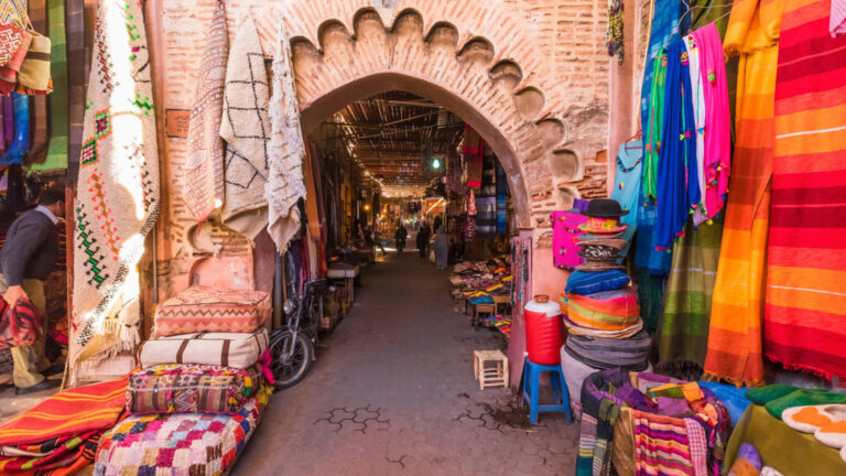 Moroccan market filled with color and stripped patterns and a beautiful arched stone walkway