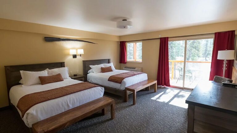 Comfort Homestead Lodge Room at McKinley Creekside Cabins with 2 queen beds, dresser, white & red decor & private balcony.