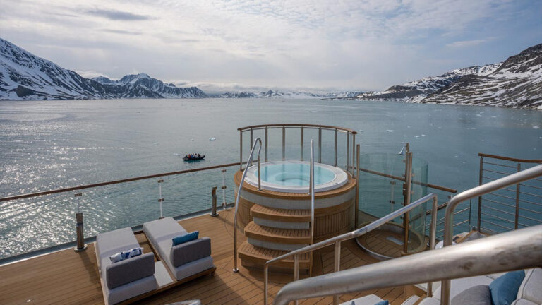 Hot tub aboard small ship cruise with lounge seating next to it on a sunny day in antarctica