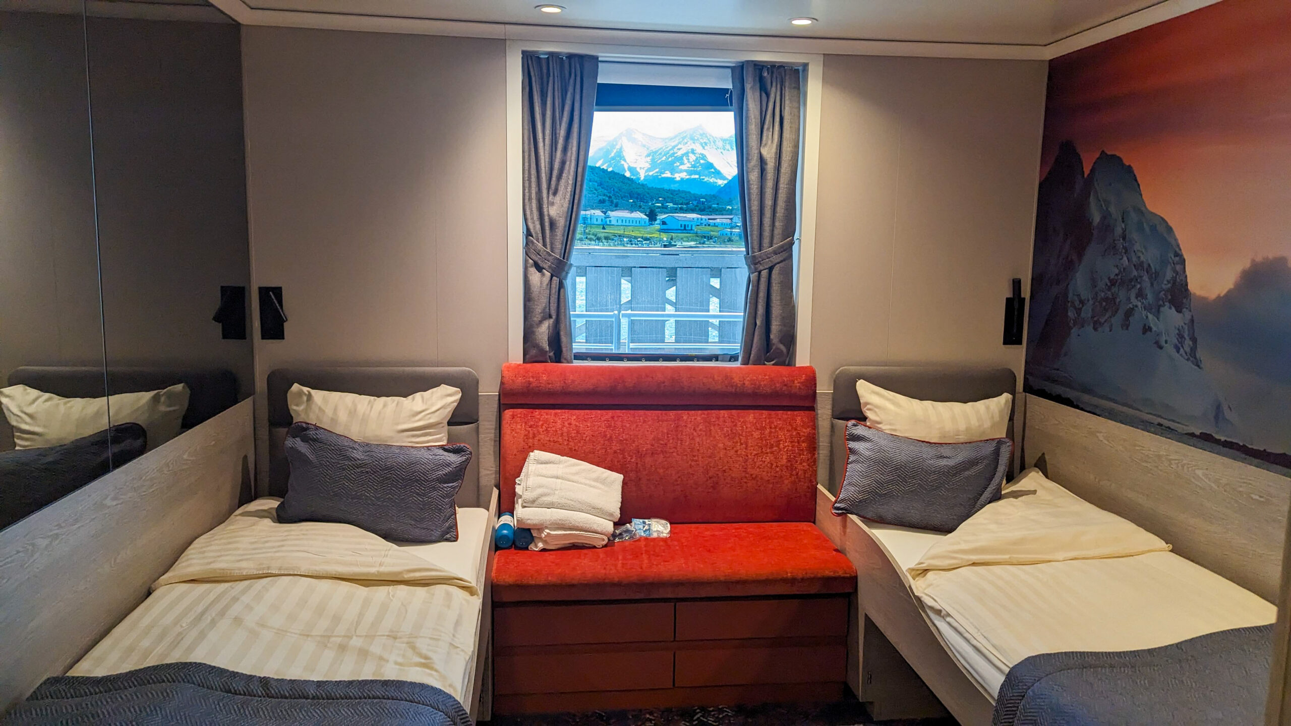 Twin window cabin aboard small expedition ship with two twin beds and porthole windows