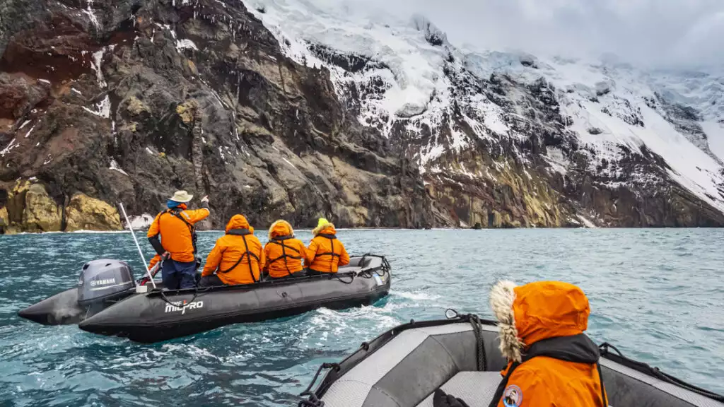 Zodiac exploring volcanic rock formations inside the caldera at Thule Island, South Sandwich Islands, Antarctica