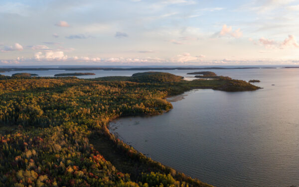 Aerial panoramic landscape view of a beautiful bay on the Great Lakes, Lake Huron, during a vibrant sunset.